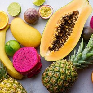 146777263-tropical-fruits-pattern-with-mango-papaya-pitahaya-passion-fruit-grapes-limes-and-pineapples-table