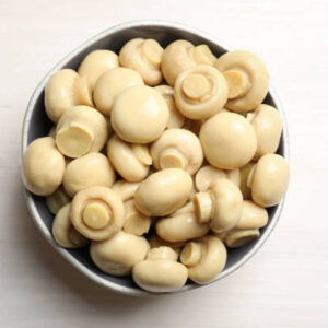 Delicious marinated mushrooms in bowl on white wooden table, top view