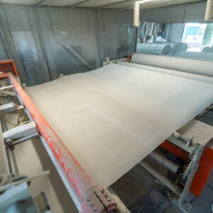 Toilet paper production. Machine with a large roll of recycled paper.