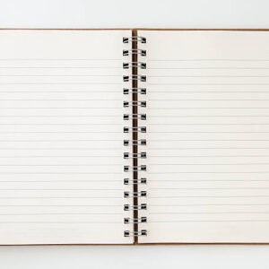 An open spiral bound notebook with lined paper