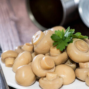 Plate with canned Mushrooms on wooden background