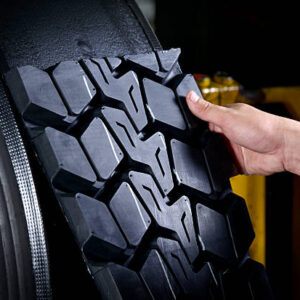 Worker sticking new rubber surface for tyre retread