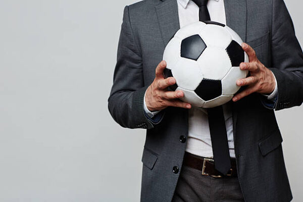 Soccer ball in hands of businessman or sport coach